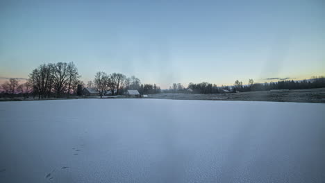 Frozen-lake-by-a-farmhouse-in-winter---time-lapse-with-shadows-crossing-the-snow