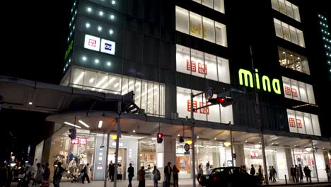 Gente-Entrando-Y-Saliendo-Del-Edificio-Del-Centro-Comercial-Mina-Kyoto-Durante-La-Noche