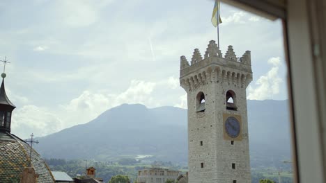 View-Through-Window-Of-Verona-Tower-With-Flag-On-Clear-Day