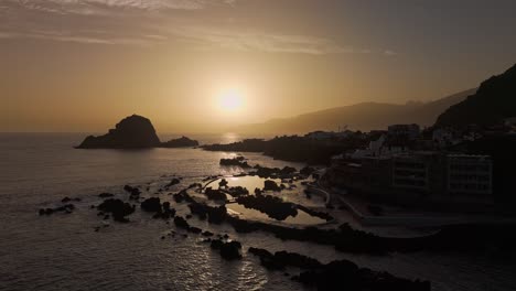 Skyline-and-relaxing-warm-sunset-over-scenic-Madeira,-Porto-Moniz-coastal,-drone-panoramic