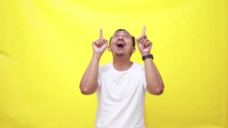 Hands,-pointing-and-up-with-a-man-on-a-yellow-screen-background-in-studio-to-promote-product-mockup