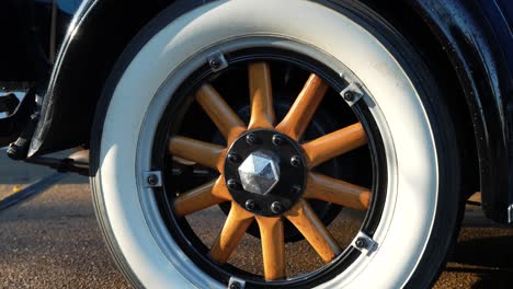 Vintage-car-wheel-with-wooden-spokes-and-white-tyre