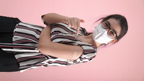 Vertical-video-of-young-woman-showing-COVID-19-vaccine-bandage-merrily