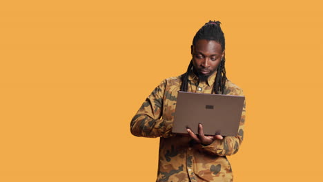 African-american-guy-looks-at-information-on-laptop