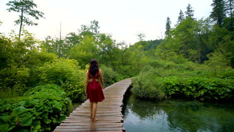 Woman-traveler-enjoys-waterfall-in-Plitvice-Lakes