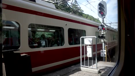 Mirando-A-Través-De-La-Ventana-Del-Tren-En-El-Tren-Koya-Expreso-Limitado-Que-Llega-Al-Andén-De-La-Estación-Gokurakubashi