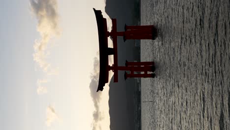 Silhouette-Of-Itsukushima-Floating-Grand-Torii-Gate-During-Sunset-With-Golden-Hour-Light-In-The-Sky-Behind