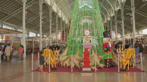 Toma-Panorámica-De-Un-Gran-árbol-De-Navidad-Durante-Las-Festividades-De-Diciembre-En-El-Mercado-De-Colón-En-Valencia,-España.