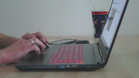 Close-Up-of-Business-Man-Working-on-a-Laptop-in-his-Homeoffice-Using-a-Touchpad
