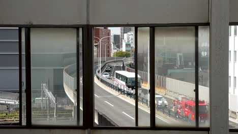 Shot-through-window-frame-of-Shin-Osaka-Station---overpass-road-with-public-traffic