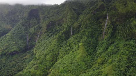 Aerial-flight-past-tall-rugged-jungle-mountain-waterfalls-in-Polynesia