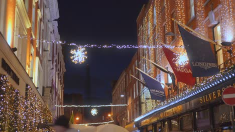 Toma-De-ángulo-Bajo-De-Luces-Navideñas-En-Las-Paredes-Exteriores-De-Casas-En-El-Corazón-De-Dublín,-Irlanda,-Por-La-Noche