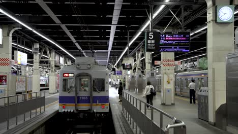 Pendler-Laufen-Am-Gleis-Nr.-5-Am-Bahnhof-Namba-Entlang,-Während-Der-Zug-Wartet