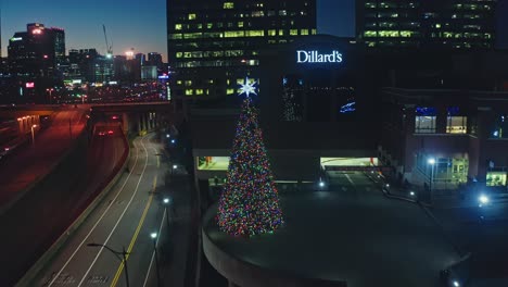Toma-Aérea-Acercándose-Al-Edificio-Dillards-Con-Iluminación-Del-árbol-De-Navidad-En-La-Ciudad-De-Atlanta-Por-La-Noche