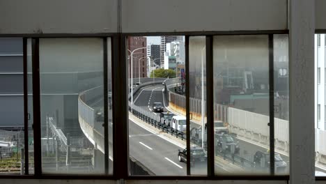 Disparo-A-Través-Del-Marco-De-La-Ventana-En-La-Estación-Shin-Osaka-Del-Paso-Elevado-Con-Tráfico-Público