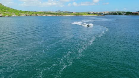 Drone-orbits-around-adventurous-couple-on-jetskis-cruising-in-Caribbean-water-bay