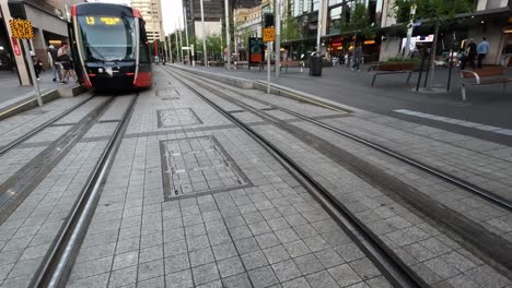 Clip-De-Mano-Caminando-Por-Las-Vías-Del-Tren-Ligero-Delante-Del-Tranvía,-Circular-Quay-Sydney