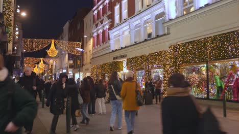 Zona-Comercial-Con-Consumidores-Por-La-Noche-Con-Luces-Navideñas-En-Diciembre,-Dublín,-Irlanda