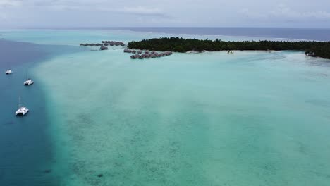 Atoll-flyover:-Over-water-villa-suites-in-Polynesian-style,-Taha'a