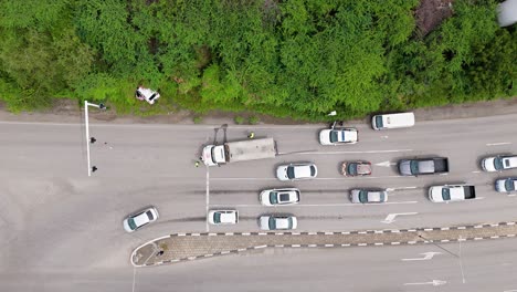 Drone-top-down-bird's-eye-view-of-emergency-first-responders-at-car-crash-site,-diverting-traffic
