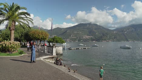 Young-Woman-in-Blue-Dress-Takes-Photos-on-the-Promenada-of-Menaggio-Town