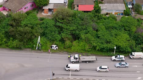 Medium-aerial-overview-of-tow-truck-and-crashed-car-in-jungle-slowing-traffic