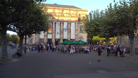 Mucha-Gente-Se-Reúne-Frente-A-La-Ópera-Nacional-Del-Rin,-Cerca-De-La-Place-Broglie-En-Estrasburgo.