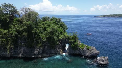 Small-isolated-island-off-the-coast-of-Nusa-Penida-on-a-hot-summers-day,-aerial