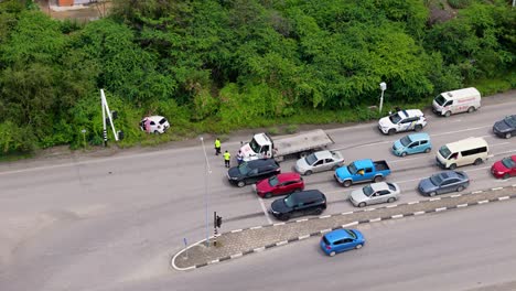 Los-Autos-Se-Alinean-En-El-Semáforo-Mientras-Los-Trabajadores-Oficiales-Con-Chalecos-Amarillos-Evalúan-La-Situación-Del-Accidente-Automovilístico.