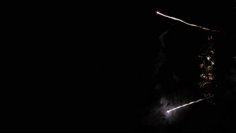 Vertical-shot-of-fireworks-shooting-up-from-below-and-going-up-in-the-air-during-a-festival