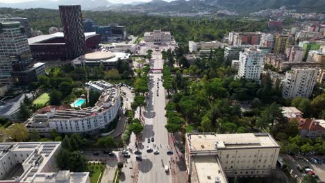 Urban-Elegance-of-Tirana,-Main-Boulevard,-Modern-Architecture-of-Stadium,-University,-and-the-Serenity-of-Green-Trees-Lining-the-Streets