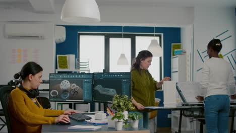 Industrial-engineer-putting-on-headset-working-at-pc-with-two-monitors