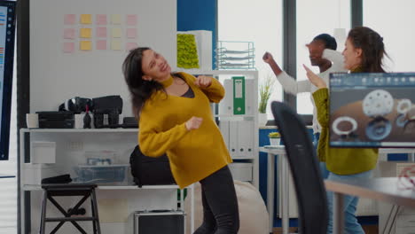 Happy-diverse-women-dancing-in-company-office-celebrating-success-of-project