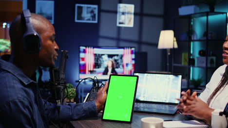 Chroma-key-tablet-in-front-of-show-host-recording-podcast,-enjoying-nice-conversation