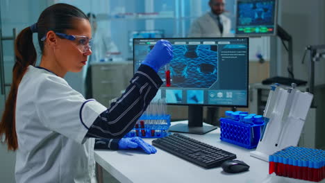 Woman-technologist-doing-a-laboratory-test-examining-a-flask-with-blood-sample