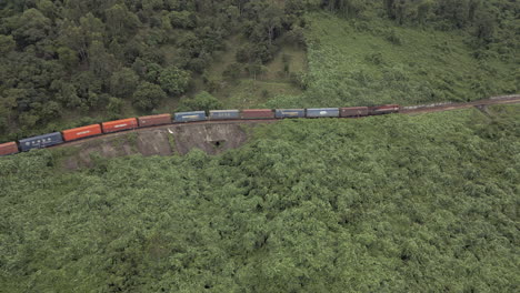 Zuglokomotive-Schleppt-Fracht-Entlang-Steilem-Gebirgspass,-Drohne-Zieht-Zurück