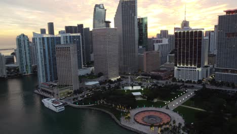 Rotación-Aérea-Lenta-Sobre-El-Parque-Frente-A-La-Bahía-En-El-Centro-De-Miami,-Revelando-El-Hermoso-Horizonte-De-La-Ciudad-Al-Atardecer