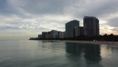 Antena-Offshore-Acercándose-A-Un-Disparo-Ascendente-Con-Velocidad-Hacia-El-Horizonte-De-Bal-Harbour-Beach-Resorts-En-North-Miami-Beach,-Florida