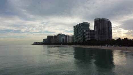 Offshore-Aerial-Approaching-Shot-Ascending-With-Speed-Towards-Bal-Harbour-Beach-Resorts-Skyline-In-North-Miami-Beach,-Florida