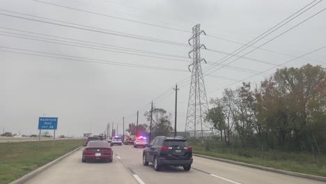 Dash-mounted-view-of-emergency-vehicles-responding-to-an-auto-accident-on-the-I-45-South-feeder-road-in-Houston,-Texas