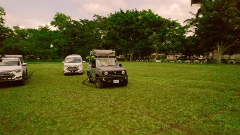 Rotating-drone-view-near-three-vehicles-standing-outdoors-during-daytime