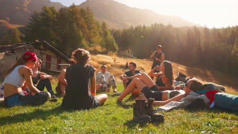 Grupo-De-Amigos-Turistas-Sentados-En-El-Césped-En-La-Región-De-Los-Alpes-Italianos-De-Courmayeur-En-Verano-Con-Un-Entorno-Pintoresco