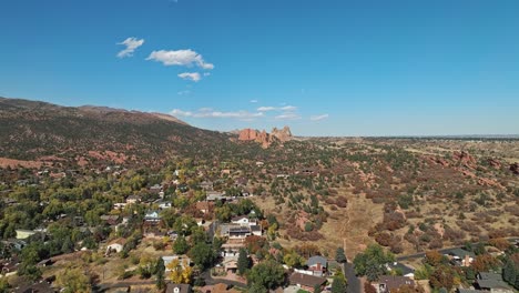 Panoramic-aerial-dolly-rises-above-neighborhood-to-Garden-of-the-Gods-Colorado-during-fall