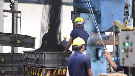 Tiro-Pov-Trabajadores-Arcilla-Negra-Cayendo-Desde-Arriba-Trabajadores-Llenando-Moldes-Dentro