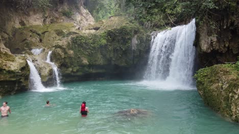 People-canyoneering-and-swimming-at-plunge-pool-of-Kawasan-falls-in-lush-jungle