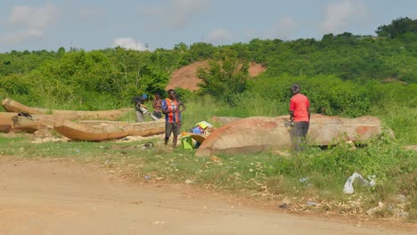 Gruppe-Afrikanischer-Tischler,-Die-Mit-Kettensägen-An-Holzkanus-Arbeiten