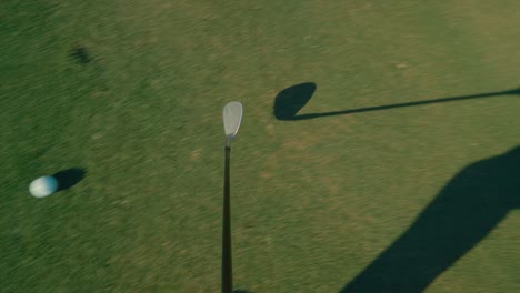 Golf-chip-shot-from-golf-club-POV,-chipping-from-the-fringe-with-wedge-locked-off-view-on-sunny-day-in-slow-motion