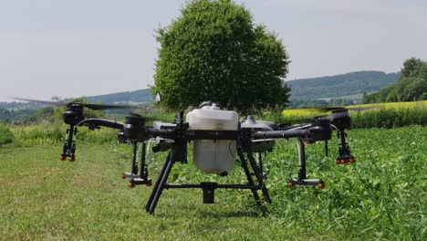 Agricultural-drone-with-spray-system-prepare-for-take-off-from-green-farm-field