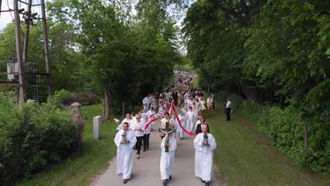 Drohnenaufnahmen-Von-Christen,-Die-Durch-Ein-Polnisches-Dorf-Marschieren