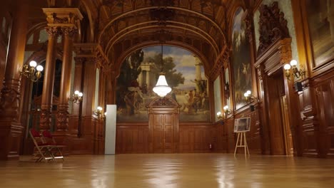 Impressive-wooden-renaissance-room-with-bright-chandelier-above-door